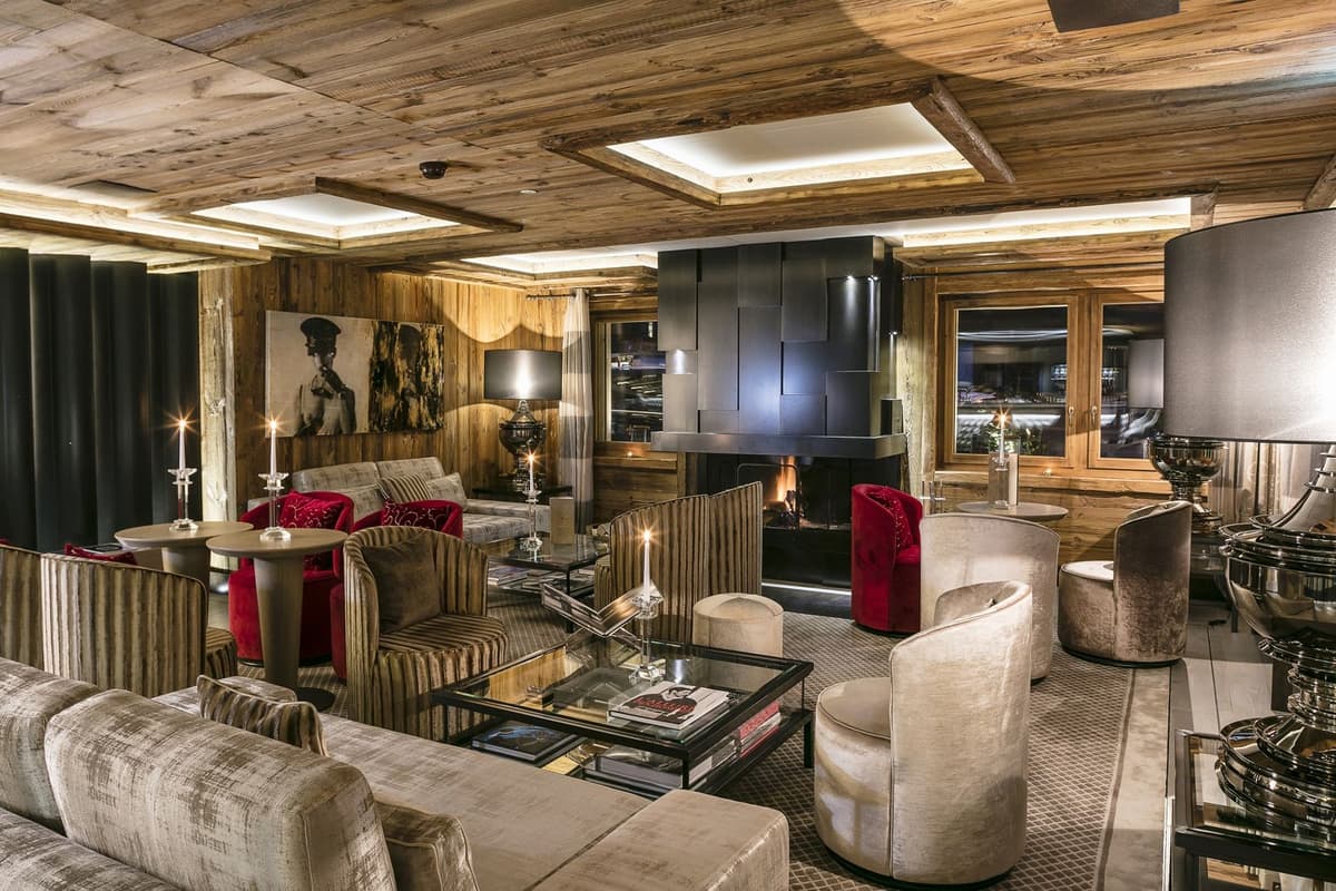 Chalet-Lounge mit Kamin, Samtsesseln und Holzvertäfelung