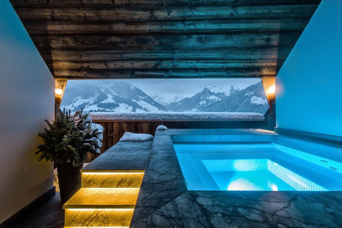 Innenpool mit Panoramafenster auf verschneite Berge